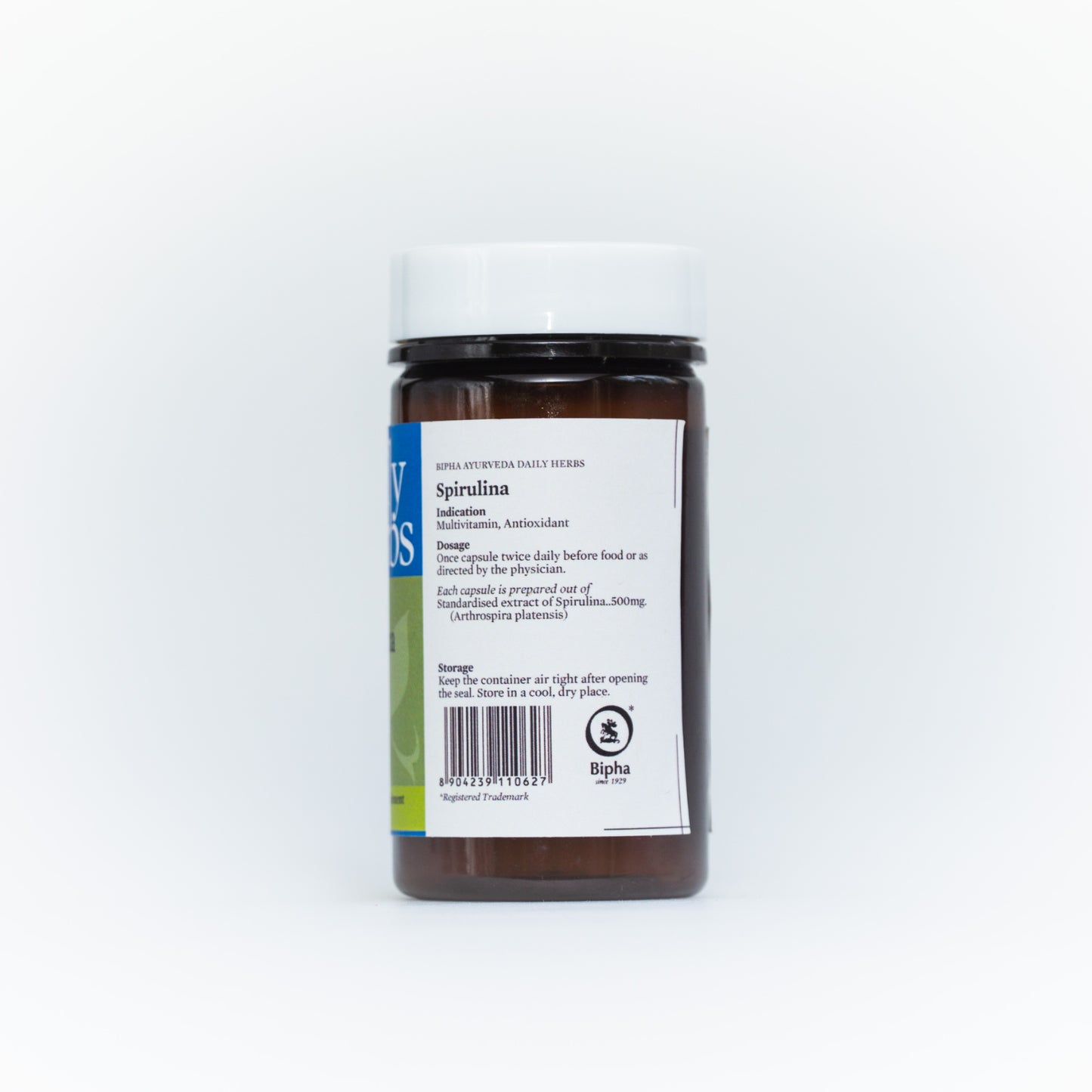 Spirulina supplement bottle with Daily Herbs back label, black cap and brown base.